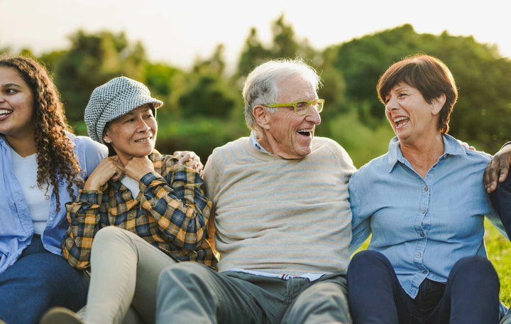 How We Can Create Joy and Purpose by Changing the Environment: four adults sitting together outdoors, smiling and laughing