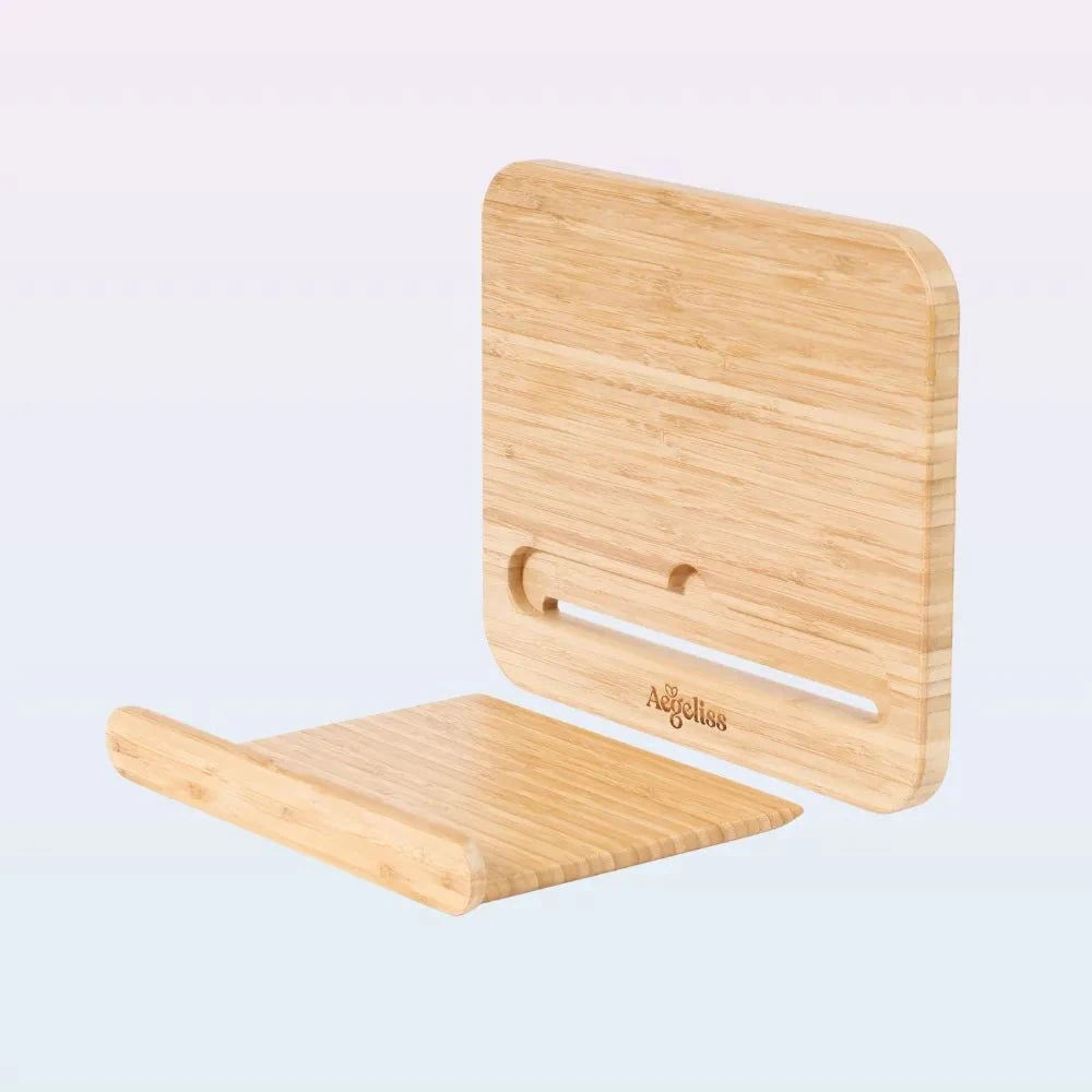 A light natural bamboo tablet stand with rounded corners, shown in two pieces: one standing upright with a cutout and the other lying flat as a base. The brand name 'Adollus' is engraved on the side.
