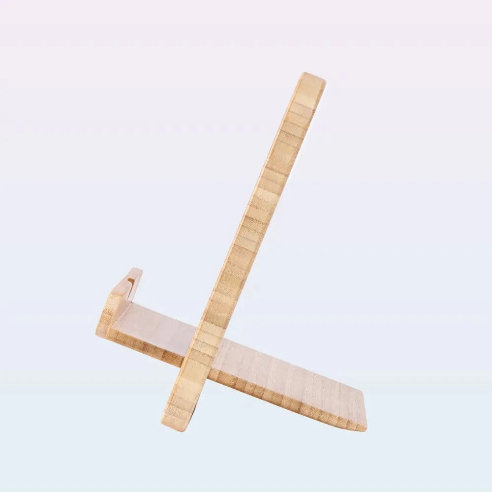A light natural wood folding stand made of two intersecting wooden pieces, shown on a plain light gray background.