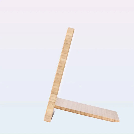 A light natural wood L-shaped stand or easel with a slanted bottom plate, shown against a plain light gray background.