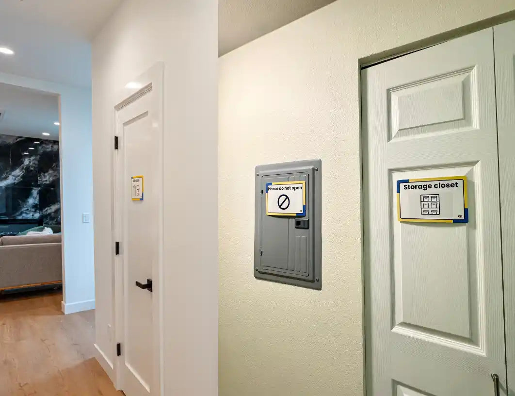 An interior hallway with white doors, a gray metal storage closet unit mounted on the wall, and a sign reading 'Storage closet.'.